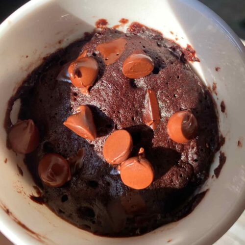 Chocolate mug cake, with strawberry and vanilla ice cream toppings.